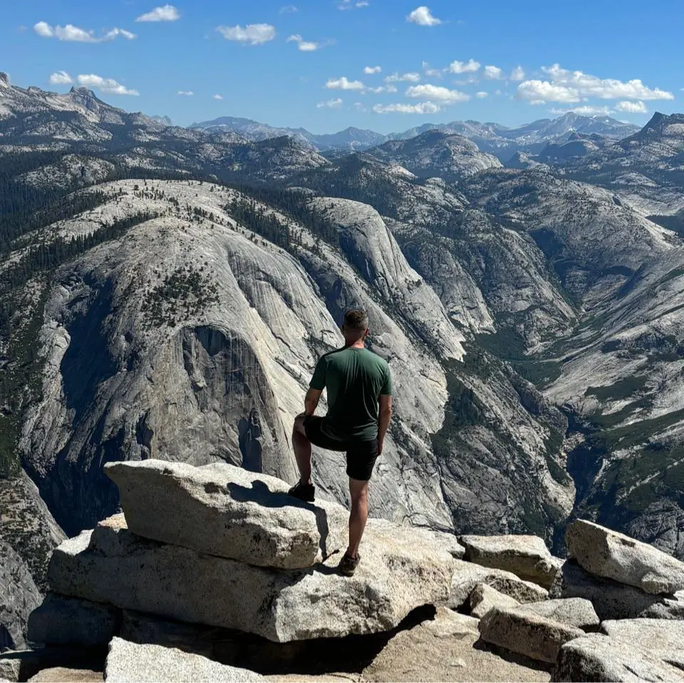 Mark Williams summiting Half Dome in Yosemite in 2024, using the LifeStraw Mission gravity filter for drinking water along the trail.